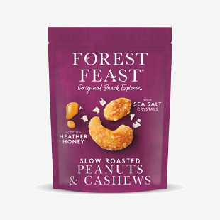 Image shows a neat grid of eight Forest Feast 120g packs. Each slender packet displays a creamy label with Scottish heather illustration, clear window revealing honey-roasted peanuts and cashews with glossy glaze, and small icons denoting fruit, nuts and seeds. Earthy tones and subtle paper texture.