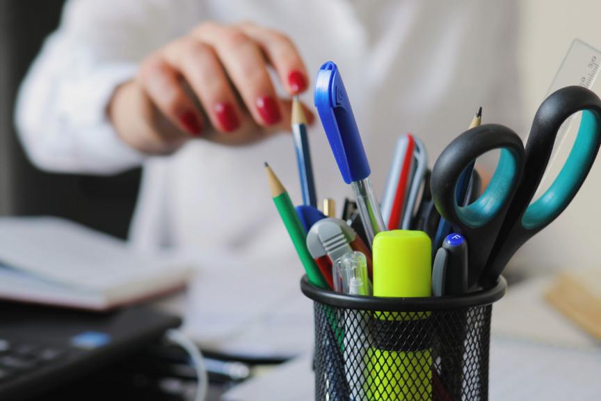 Desk with stationery and pen pot. 