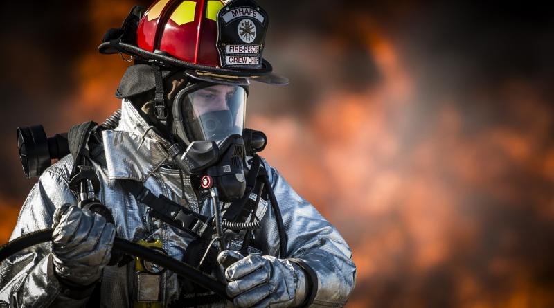 fireman looking away from blaze with mask on