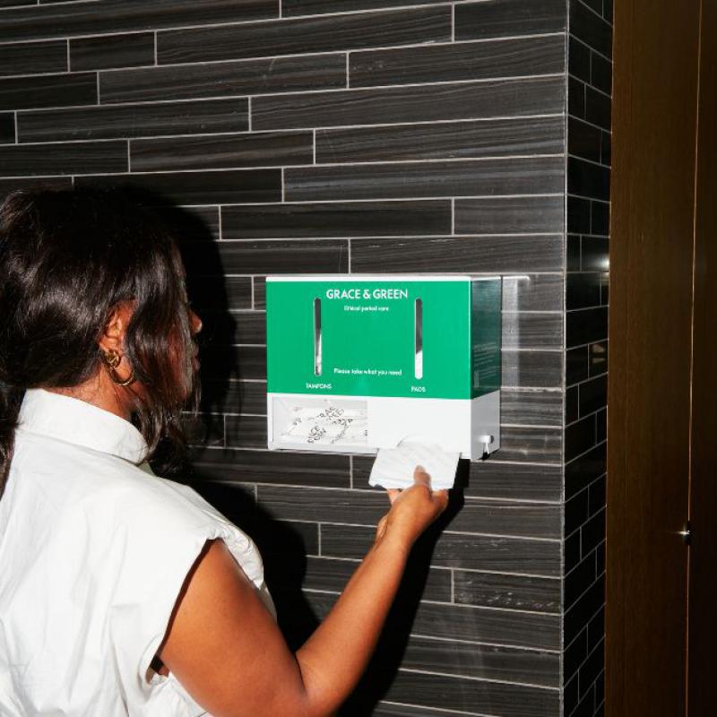 Woman using Grace & Green Dispenser at Work