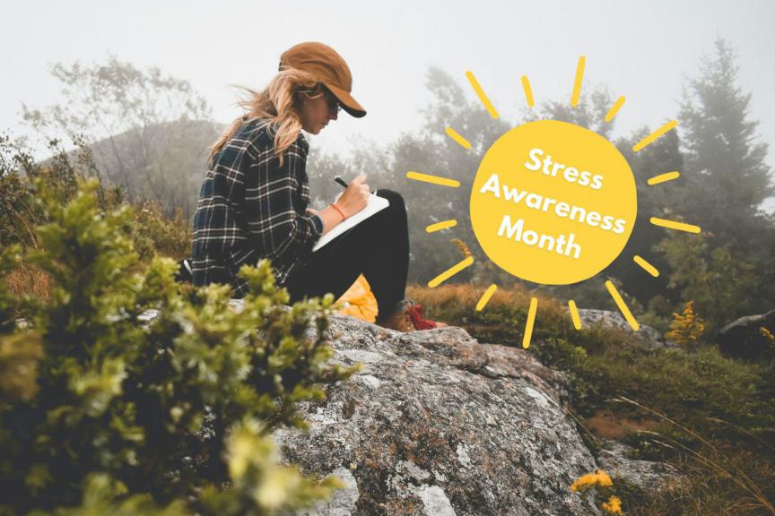 Image of woman journaling outside with flowers around her. 