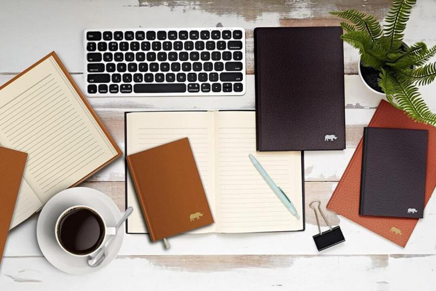 Rhino notebooks on a table with a keyboard and plants 