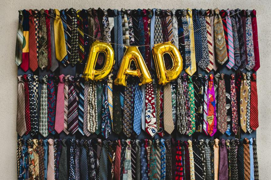 'Dad' in balloons with a background of assorted ties. 