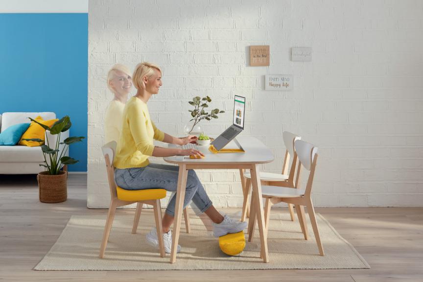 Woman sitting at desk working with Leitz Ergo accessories 