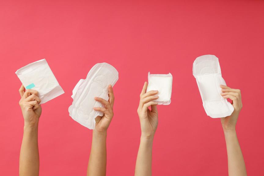 Hands holding up period products. 